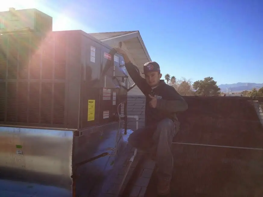 HVAC technician performing Boiler Repair on a rooftop unit in Green Lake